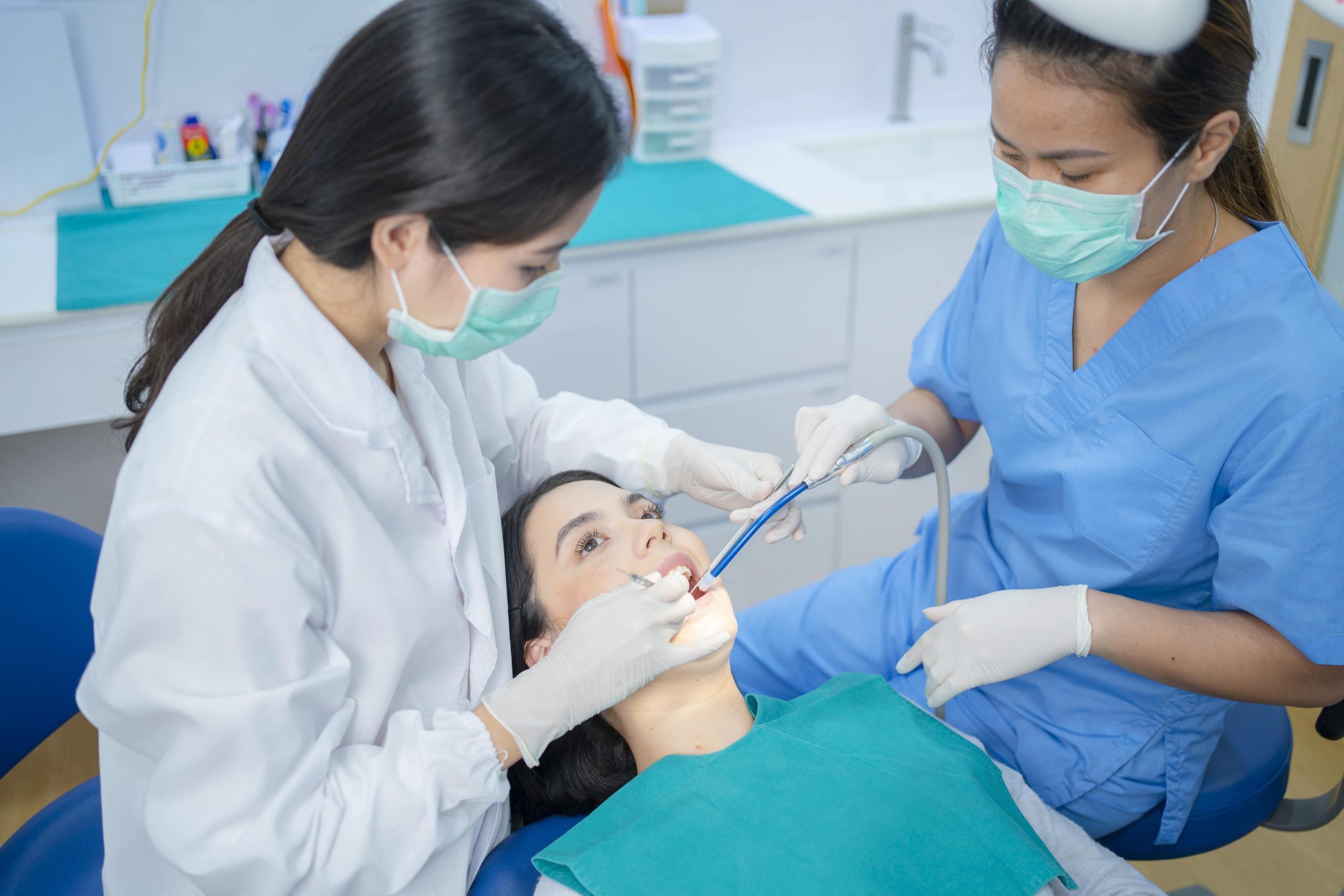 Young dentist providing treatment to patient fully relaxed in the dentist chair
